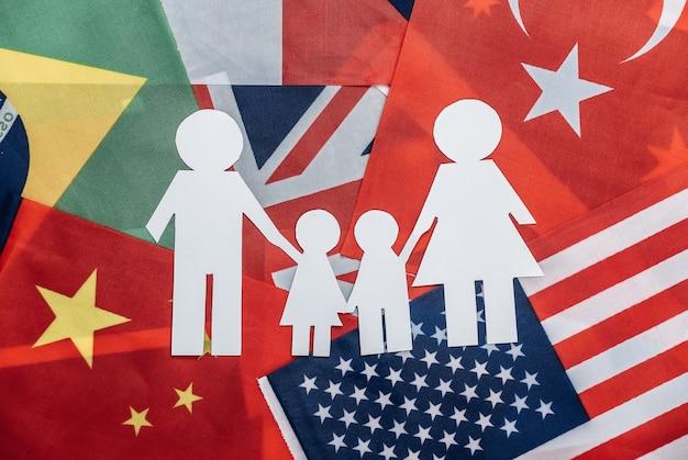 Paper cut family chain on of many flags. International family