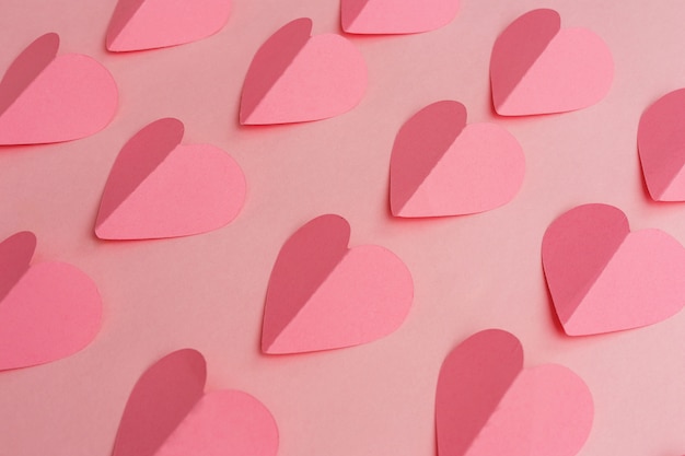 Paper cut of pink hearts on pink background