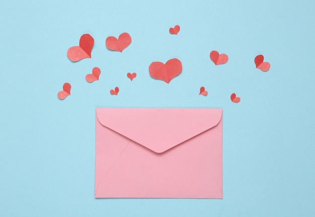 Paper Cut Red hearts and envelope on blue background Valentines day concept