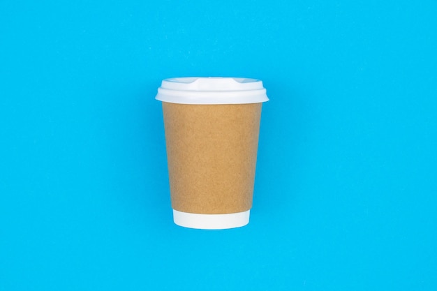 Paper disposable cup on a blue background flat lay