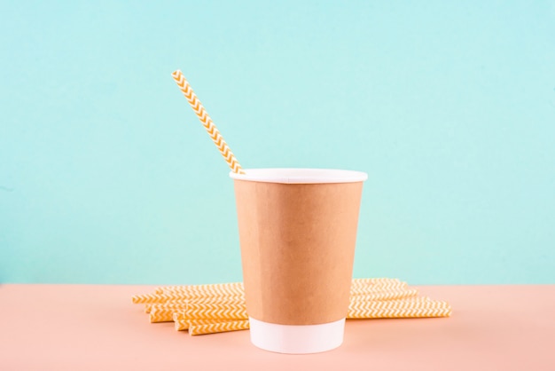 Paper glass with drinking tubes. Eco utensils on a light background.