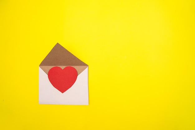 Paper heart in an envelope on yellow