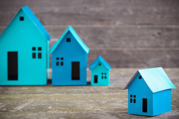 A paper houses stands over a wooden background