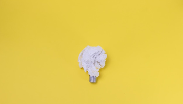 Paper light bulb on yellow background