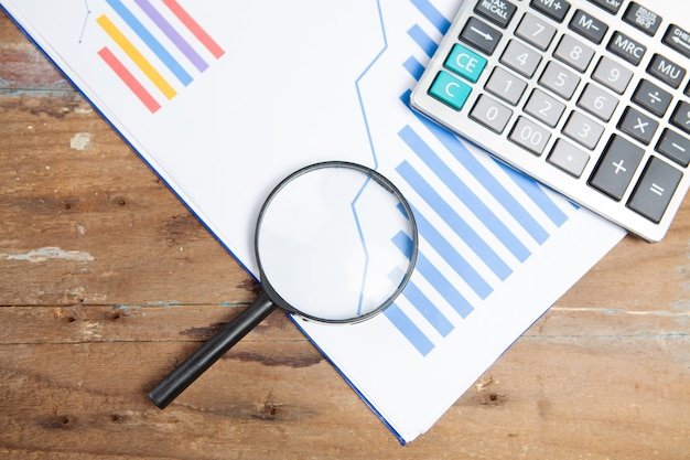 Paper, magnifier and calculator on the table