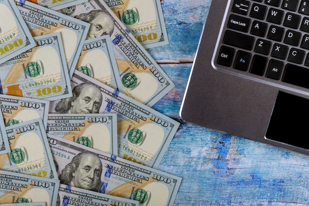 Photo paper money 100 dollar bills on laptop keyboard financial concept