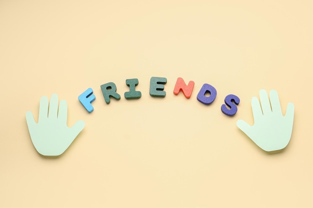 Photo paper palms and word friends on beige background friendship day celebration