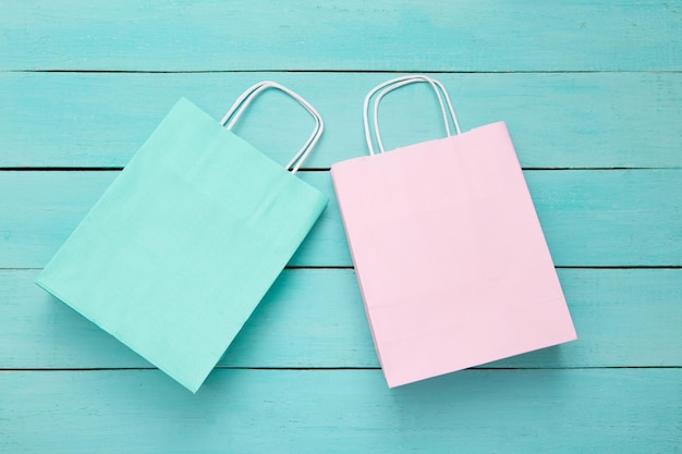 Paper shopping bags on blue wooden background Top view