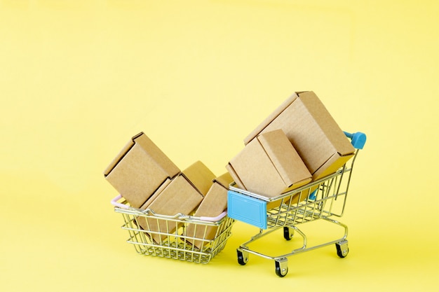 Paper shopping bags in a shopping cart on yellow