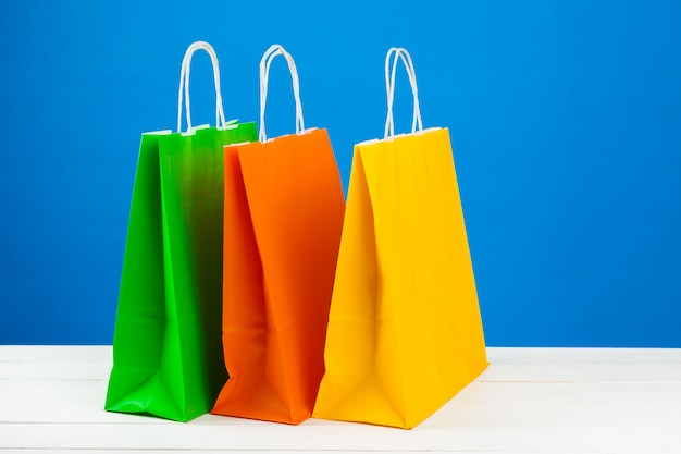 Paper shopping bags with copy space on blue background