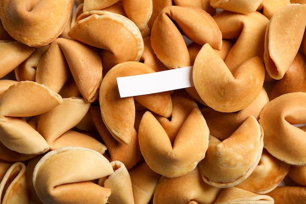 Paper with prediction on pile of fortune cookies top view