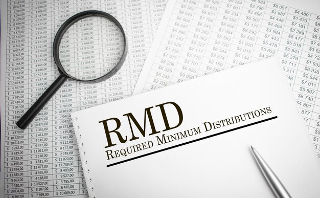 Paper with Required Minimum Distributions RMD on a table with pen chart and magnifier