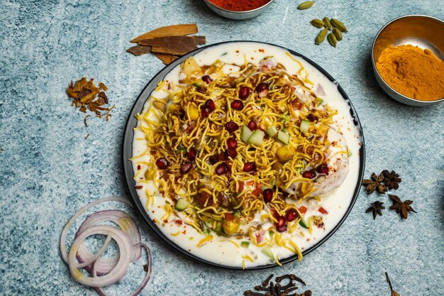 Papricha chotpoti with pomegranate seeds served in a dish isolated on grey background top view of bangladesh food