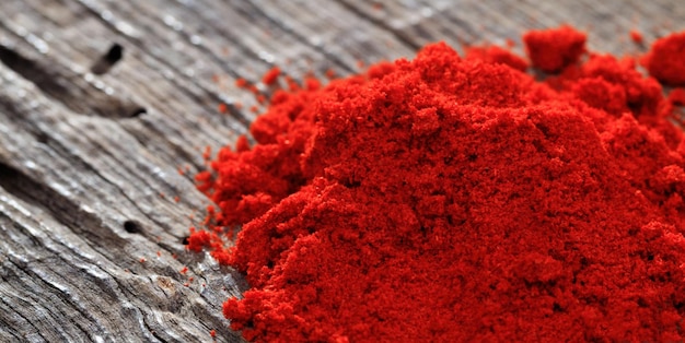 Paprika powder close up on a wooden table copy space