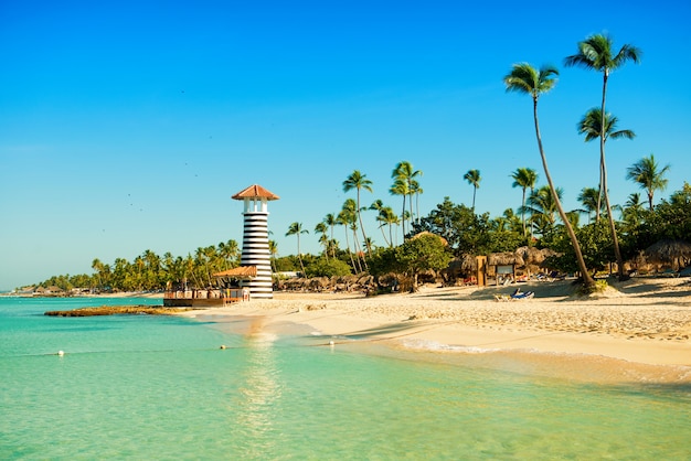 Paradise tropical island in Dominican Republic. White sand, blue sea, clear sky and  lighthouse on shore