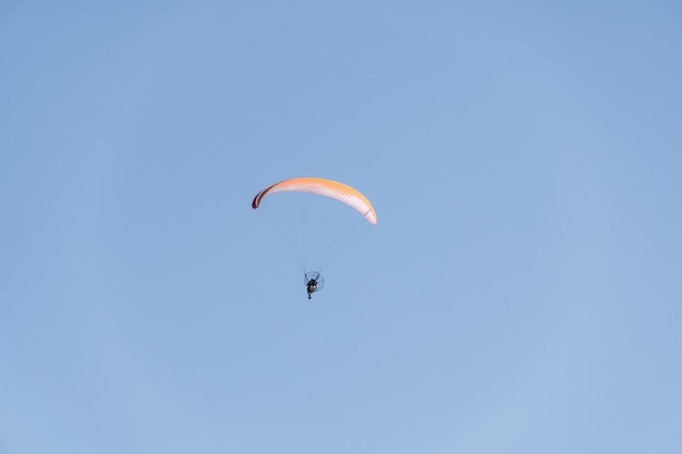 Paraglider flying over Saquarema beach, Rio de Janeiro. Sunny day with blue sky in the background.