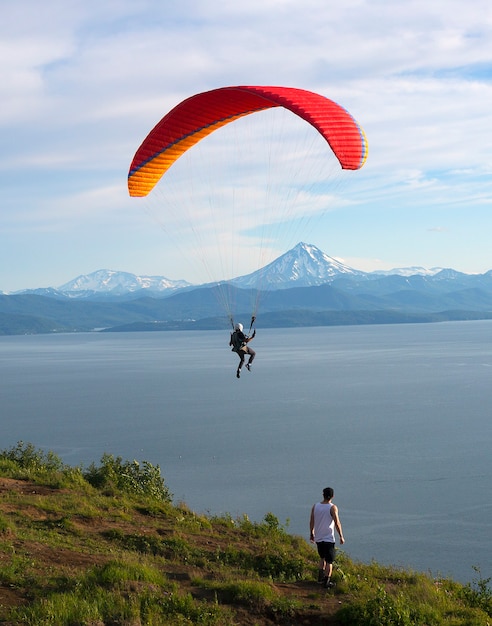 Paraglider is flying in the blue sky against the background of clouds.