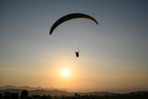 paraglider pilot fly in sky with beautiful sunset Paragliding concept