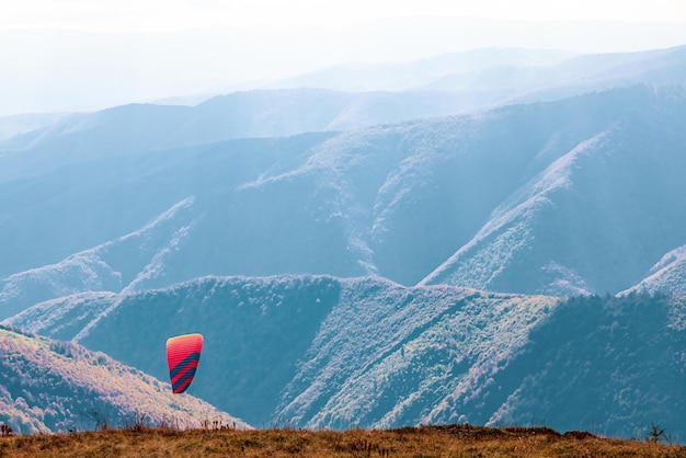 Paragliding active sport against giant mountains in highland