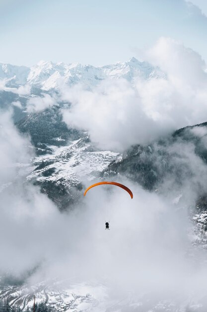 Photo paragliding on a cloudy day through the mountain