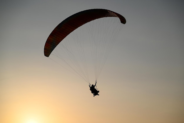 paragliding at sunset in mountain silhouette of paraglider