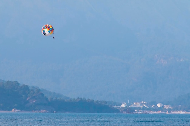 Parasailing over sea on a background of mountains