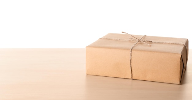 Parcel gift box on wooden table against white background