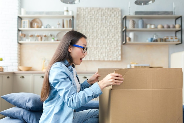 Parcel home delivery happy young beautiful asian woman received parcel excited by surprise she opens