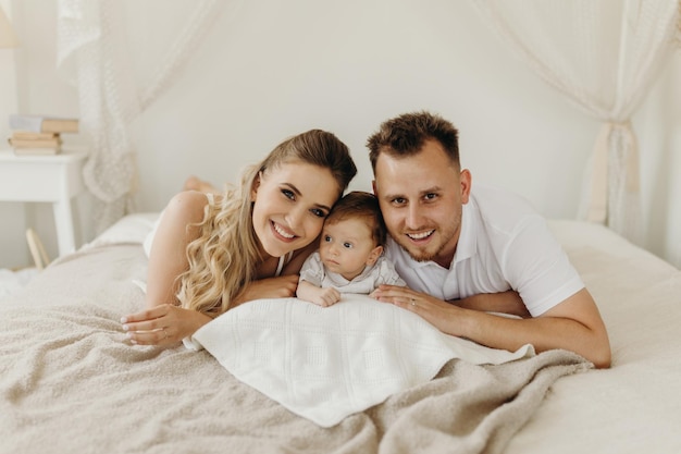 Parent and baby happy family having fun in bed portrait happy family