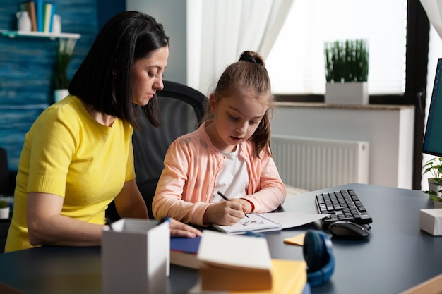 Parent helping little daughter with school homework