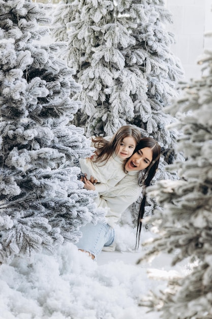 Parent and little child having fun near Christmas tree indoors Loving family with presents in room