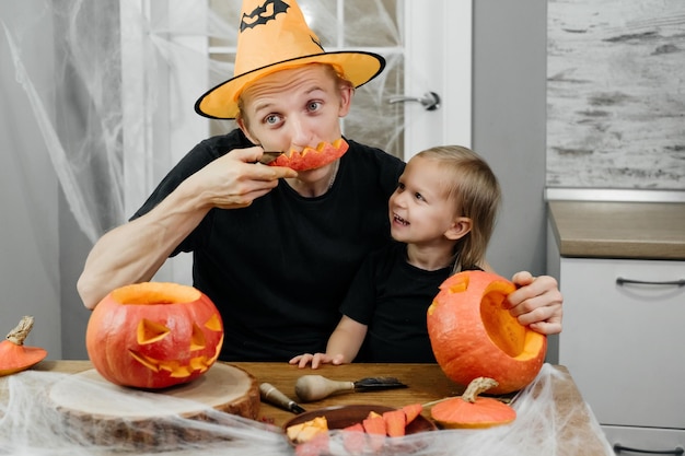 Parent with chld are carving pumpkin for halloween