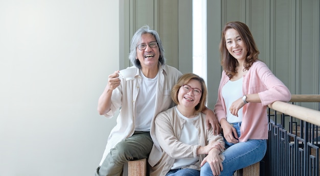 Parents and daughters happily embrace each other in the living room while taking pictures together within the family.