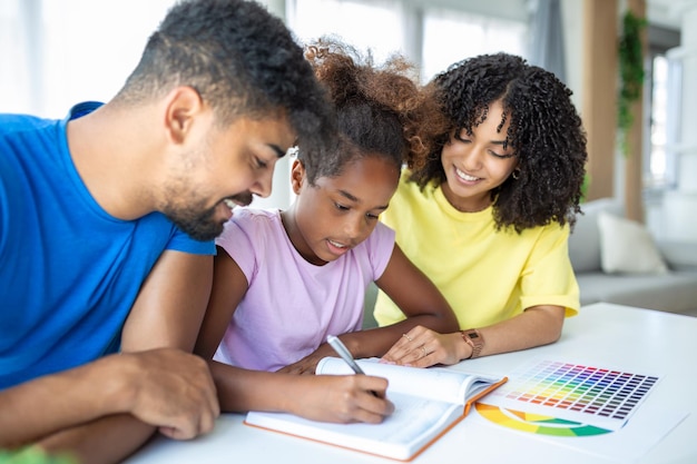 Parents helping child with her homework at home Father and mother helping daughter studying at home