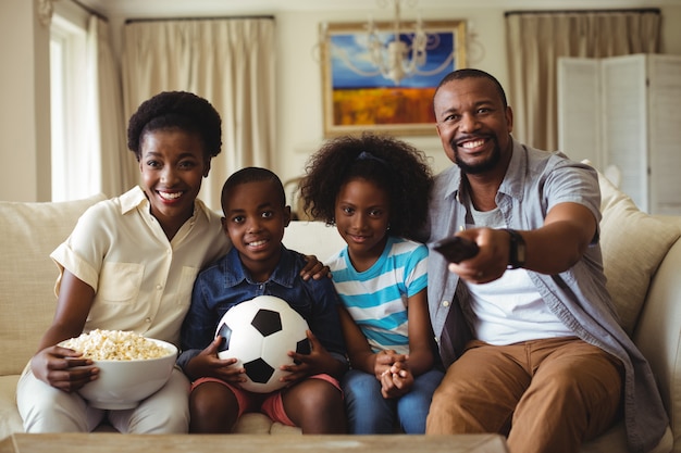 Parents and kids watching television in living room