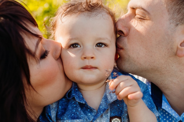 Parents kiss pretty little boy