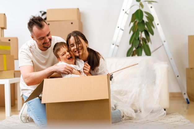 Parents and son packing boxes and moving into a new home