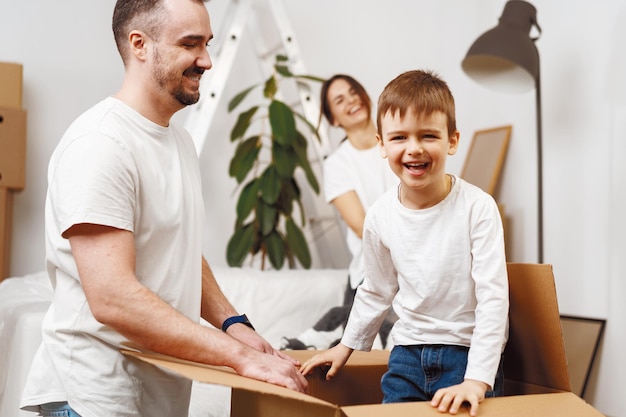 Parents and son packing boxes and moving into a new home