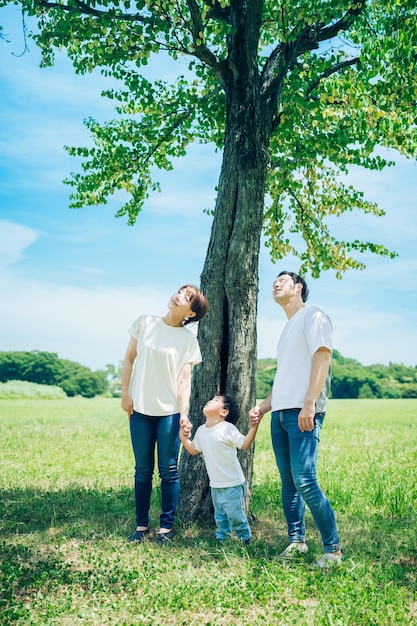 Parents and their child lined up under a tree