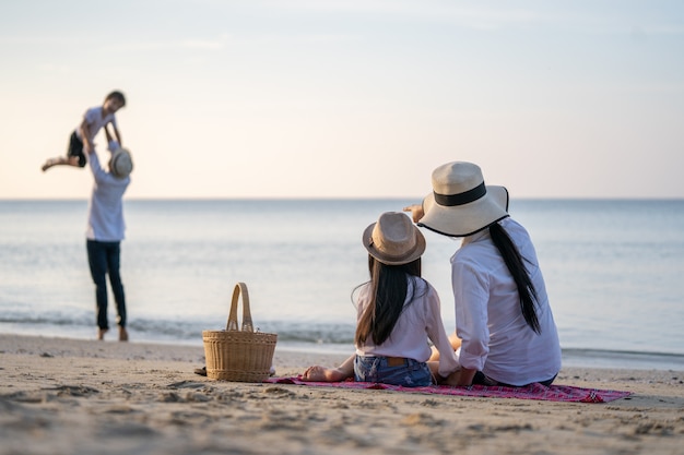 Parents with children enjoying vacation on beach