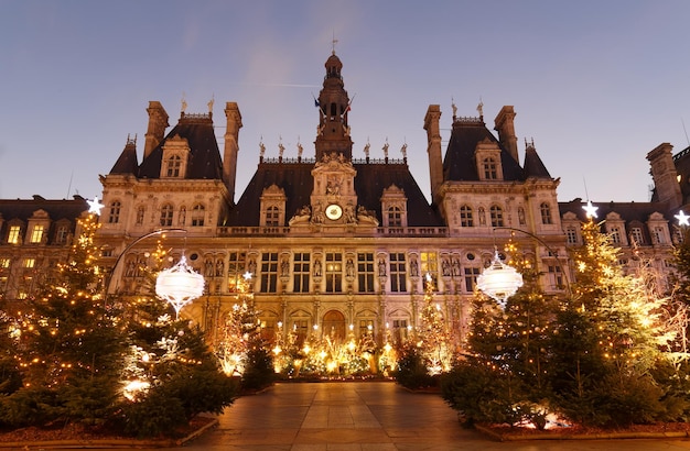 Parisian City Hall decorated with Christmas trees for winter holidays at night Winter travel and tourist attractions in Europe concept Celebration background