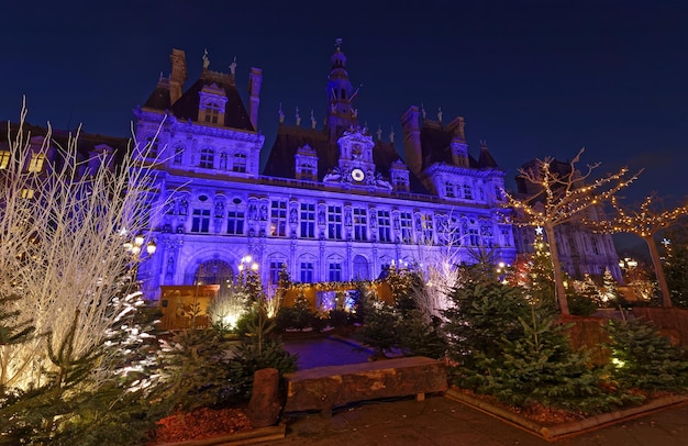 Parisian City Hall decorated with Christmas trees for winter holidays at night Winter travel and tourist attractions in Europe concept Celebration background