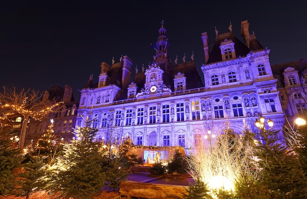 Parisian City Hall decorated with Christmas trees for winter holidays at night