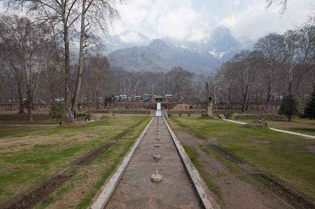 Photo a park in srinagar india with a bridge walkway village and large mountain