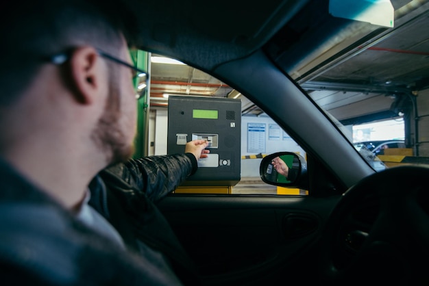 Parking barrier man taking ticket to pass control on parking area