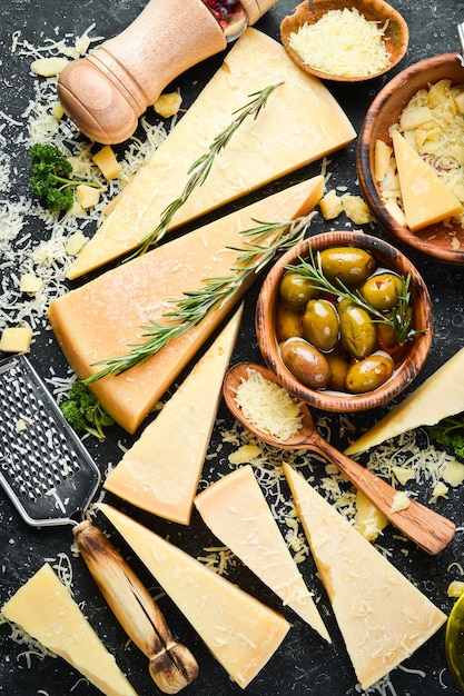 Parmesan cheese and snacks on a stone table Top view On a concrete background