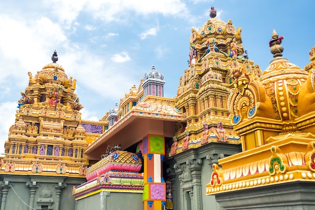 Part of a beautiful and colorful Indian temple in Mauritius Island. Close-up on sculptures and statues of Indian deities.