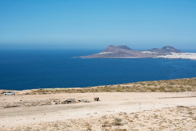 Part of the coast of an island, tropical landscape with a huge blue sea and the land illuminated by the summer sun.