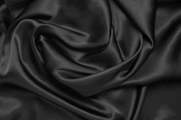 Part of the dark fabric texture of the fabric for the background and decoration of the work of art a beautiful crumpled pattern of silk or linen A crumpled piece of cloth