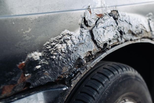 Part of the fender and bumper of a passenger car with damage from through corrosion Selective focus